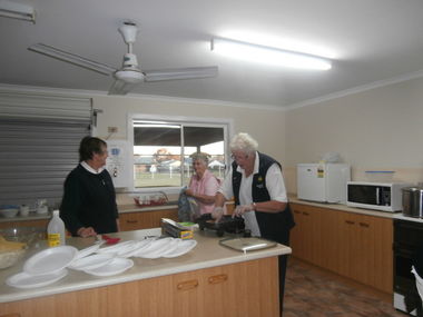 Joan McCalman and girls in kitchen preparing lunches
